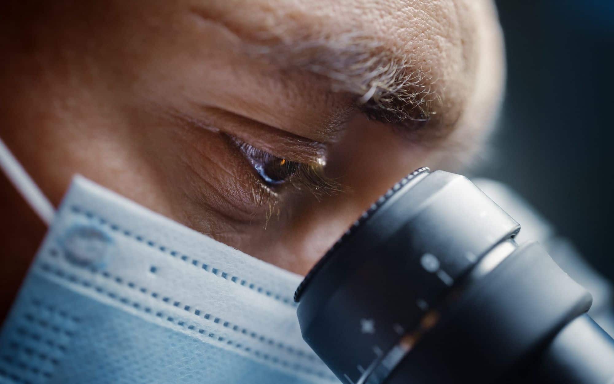 Laboratory scientist examining a sample through a microscope