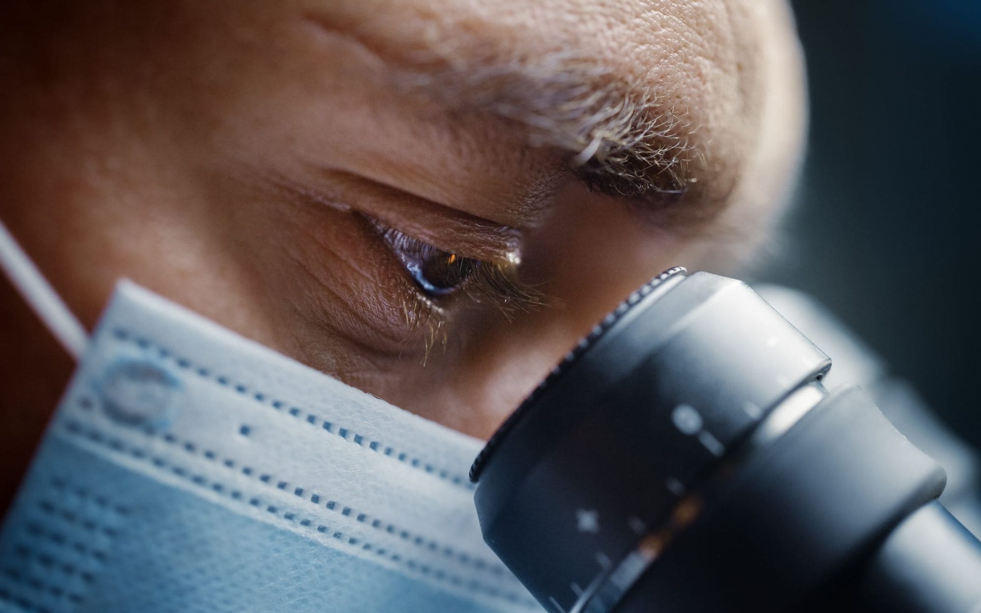 Laboratory scientist examining a sample through a microscope